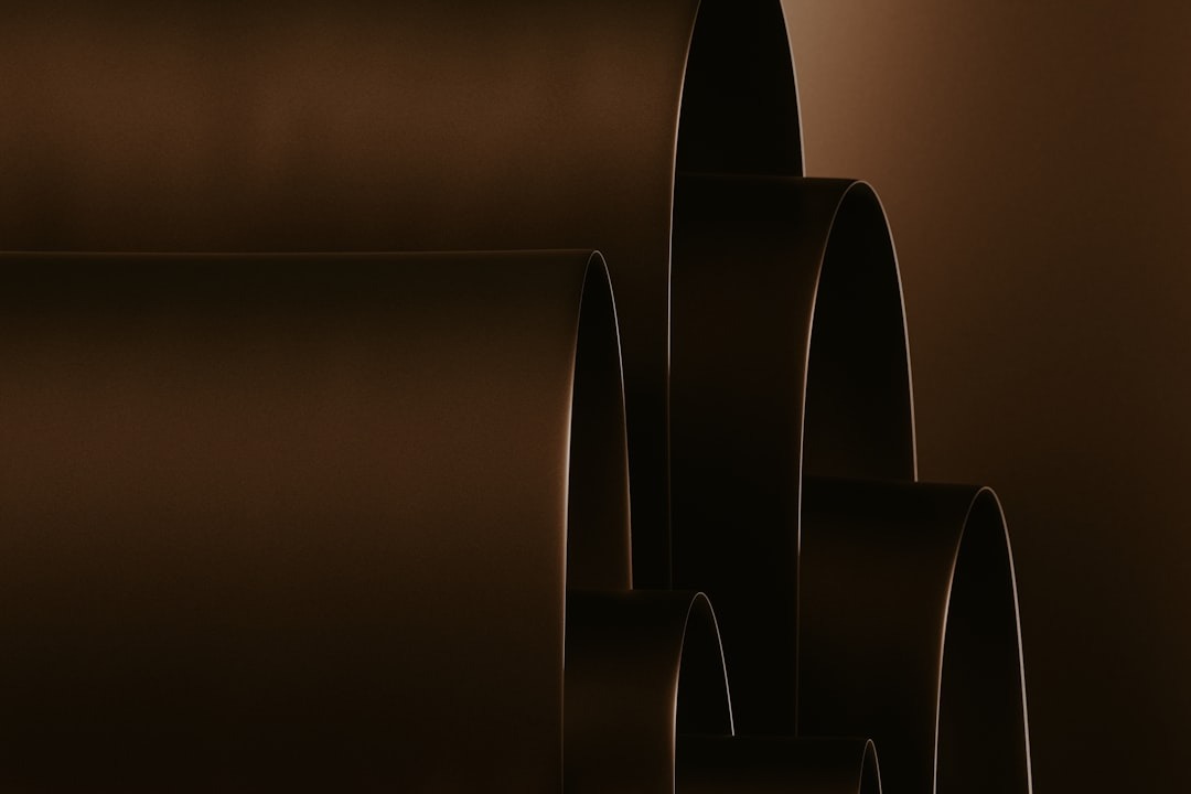 Layered dark brown curved shapes create an architectural pattern.